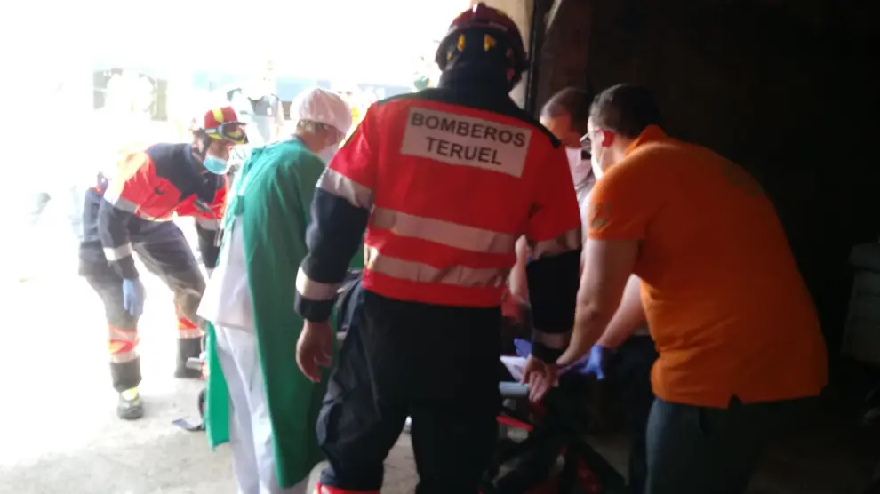 Personal sanitario atiende al operario que ha caído en un algibe en Alloza mientras los bomberos esperan para trasladarlo