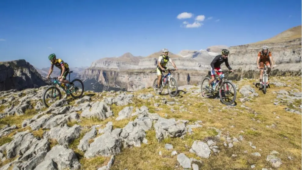 Imagen de una web oficial de turismo con ciclistas en Ordesa, una actividad prohibida.