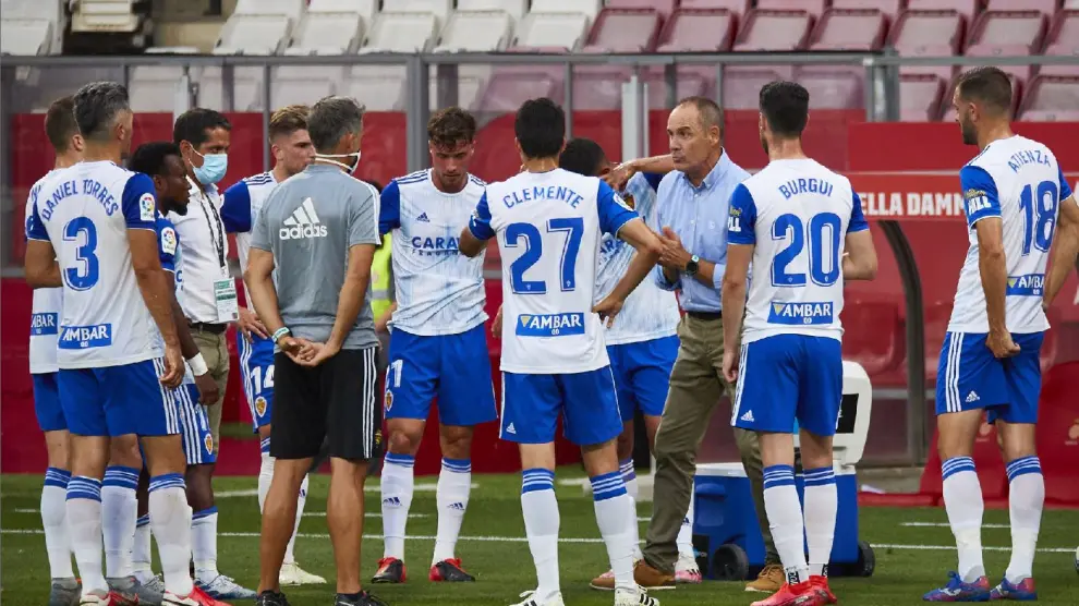 Los jugadores del Real Zaragoza escuchan las consignas de Víctor Fernández en una de las pausas de hidratación este viernes en Gerona.