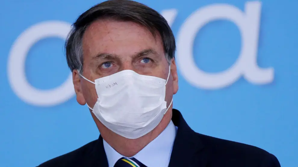 FILE PHOTO: Brazil's President Jair Bolsonaro wearing a protective mask looks on during the launching ceremony of the Plano Safra 2020/2021, action plan for the agricultural sector, in Brasilia