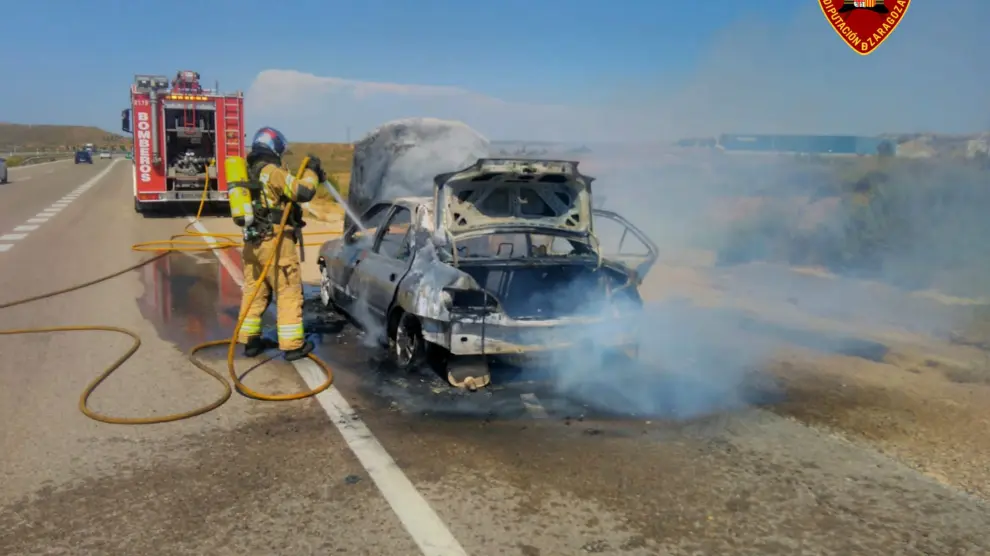 Los bomberos extinguen el fuego de un coche en la A-23, a la altura de Muel.