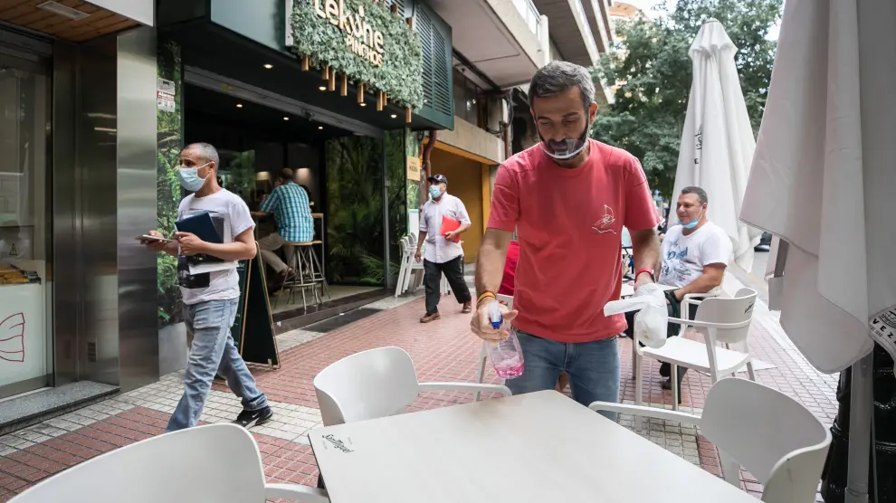 Óscar Gargallo, del bar Lekune, desinfecta un bar de la terraza.