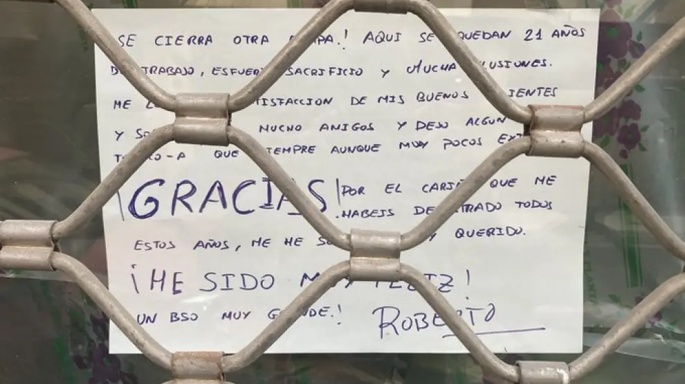Letrero que cuelga del escaparate de la Floristería Atenea Roberto Serena en Zaragoza
