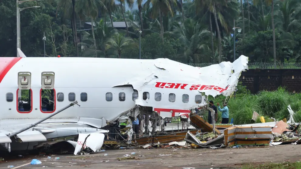 Officials inspect the site where a passenger plane crashed when it overshot the runway at the Calicut International Airport in Karipur