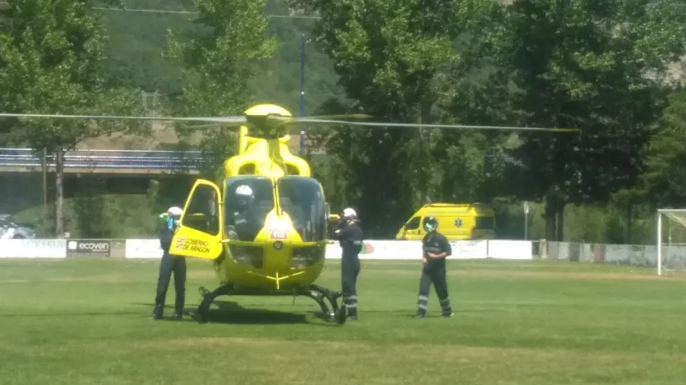 El helicóptero del 112 esperando en el campo de fútbol de Biescas para la transferencia de un montañero herido en Panticosa.