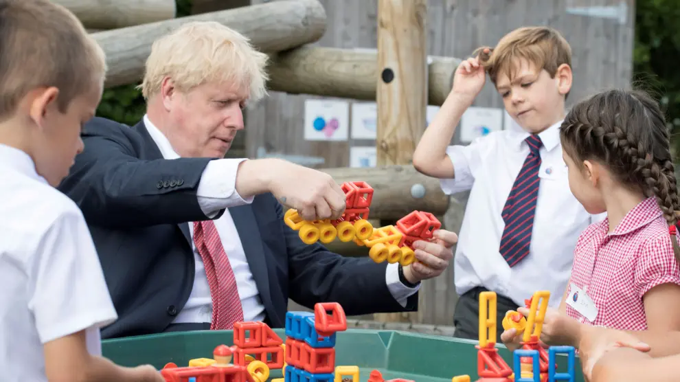 El primer ministro británico juega con varios estudiantes durante una visita.
