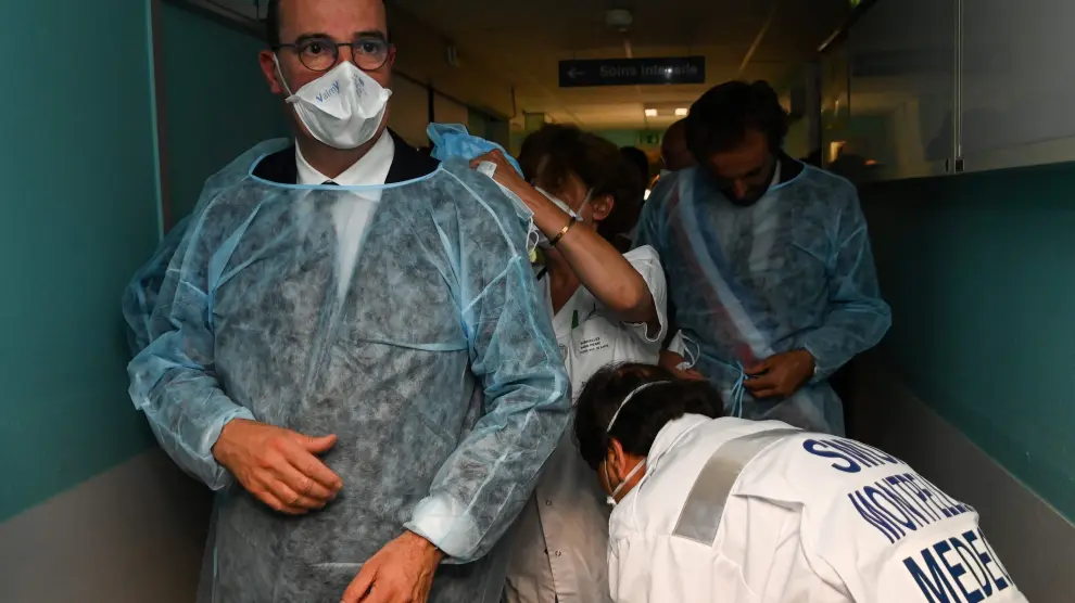 11 August 2020, France, Montpellier: French Prime Minister Jean Castex (L) puts on a coverall suit during a visit at the CHU hospital in Montpellier. Events involving more than 5000 people will remain banned in France until at least the end of October 2020 amid the coronavirus pandemic. Photo: Pascal Guyot/AFP/dpa11/08/2020 ONLY FOR USE IN SPAIN [[[EP]]] 11 August 2020, France, Montpellier: French Prime Minister Jean Castex (L) puts on a coverall suit during a visit at the CHU hospital in Montpellier. Events involving more than 5000 people will remain banned in France until at least the end of October 202