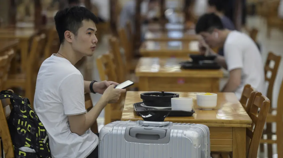 Estudiantes comen en una mesa del campus de la  Universidad de Ciencia y Tecnología de Huazhong en Wuhan