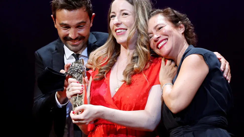 Pilar Palomero sostiene el galardón flanqueada por los productores de la película, Álex de la Fuente y Valeire Delpierre.