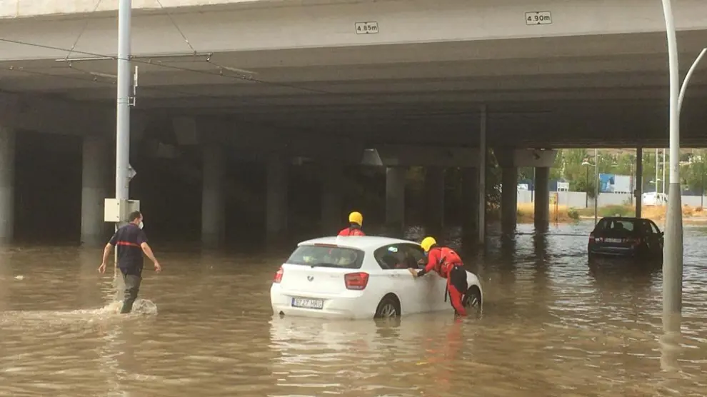 Intervención de los Bomberos de Zaragoza en la calle Luciano Gracia del Actur para ayudar a los coches afectados por la tromba de agua.