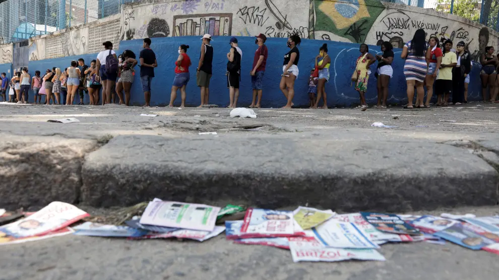 La gente hace fila para votar en una favela de Río de Janeiro.