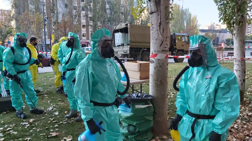 Militares ataviados con la equipación especial anticovid para desinfectar la residencia de la APAC en el Actur de Zaragoza, este lunes.
