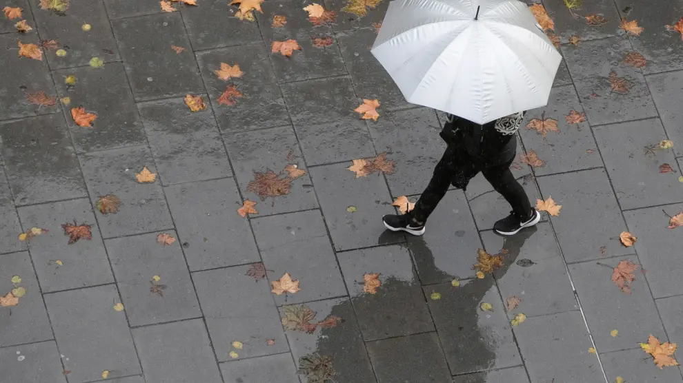 Una persona camina bajo la lluvia en una imagen de archivo. Aemet en Aragón prevé para los próximos días una sucesión de frentes, con precipitaciones.