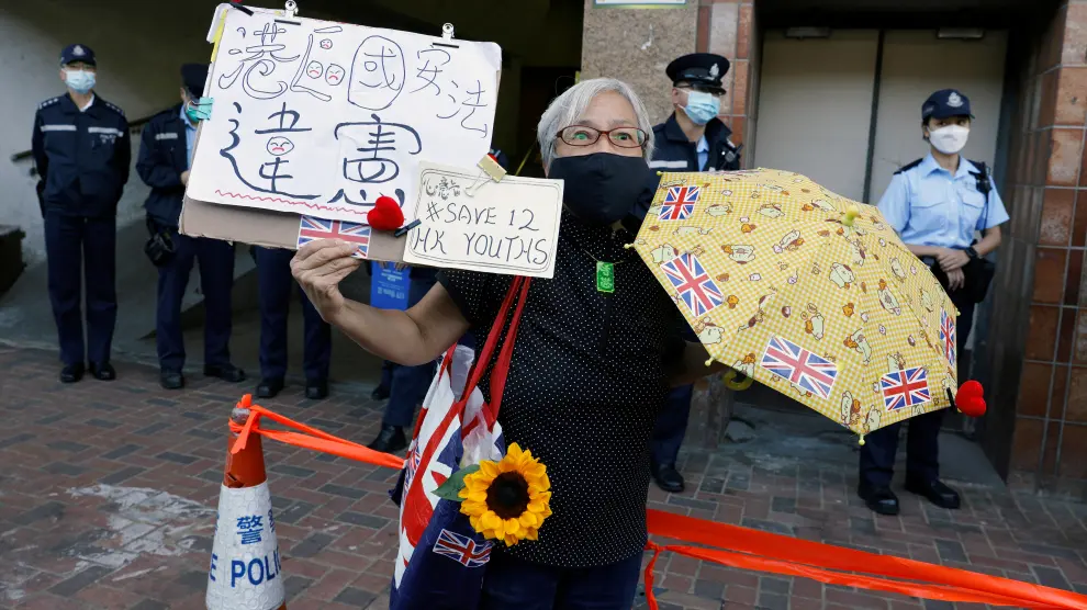 Pro-democracy activist Alexandra Wong holds placards during a protest to urge for the release of 12 Hong Kong activists outside China's Liaison Office, in Hong Kong
