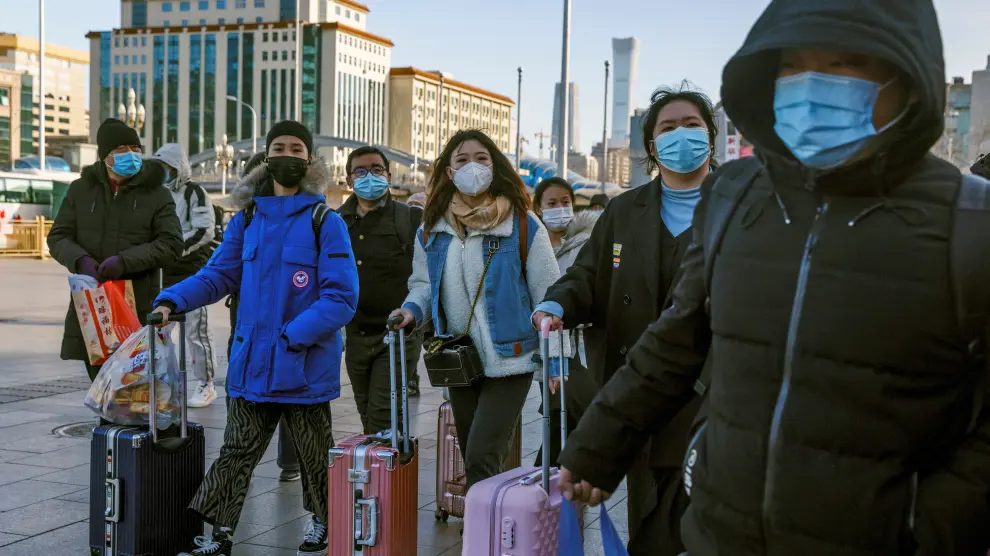 Travellers push suitcases outside Beijing Railway Station following an outbreak of the coronavirus disease (COVID-19) in Beijing