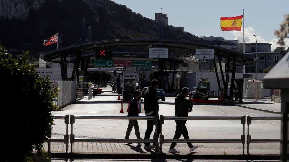Pedestrians walk past the border between Spain and Gibraltar