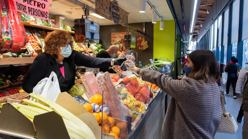 Una consumidora adquiere fruta en un puesto del Mercado Central de la capital aragonesa.