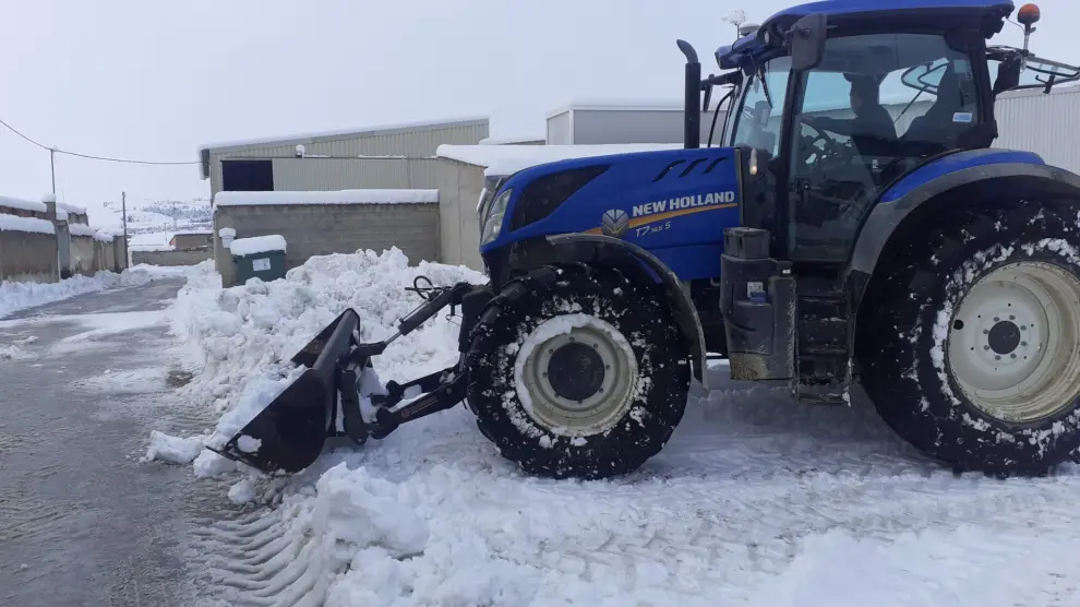 Un agricultor retira con su tractor la nieve acumulada en las calles de su municipio.