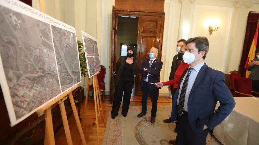 El alcalde de Huesca, en primer término, contempla los paneles donde se define la superficie y la ubicación del suelo cedido para el centro de emergencias y seguridad ciudadana.