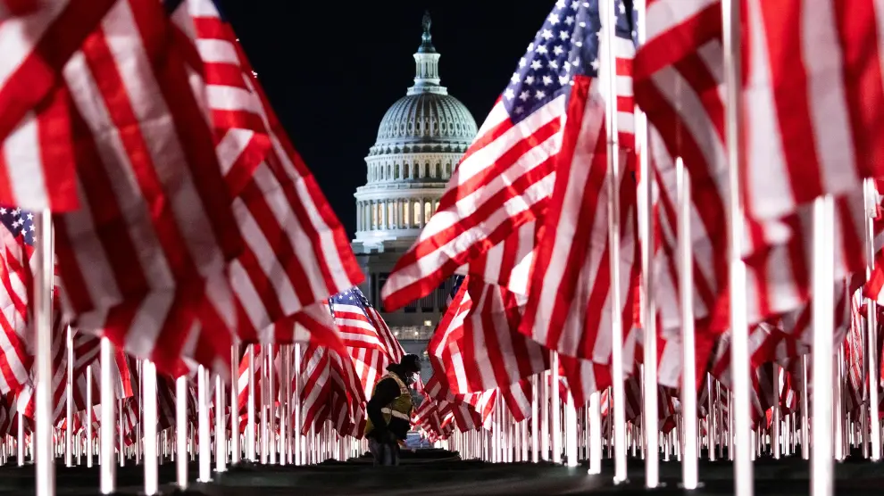 Una persona pasa entre las 200.000 banderas instaladas frente al Capitolio para la investidura de Biden.