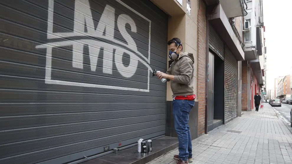 El grafitero Antonio Miró decora una persiana de una empresa en la calle José Pellicer.