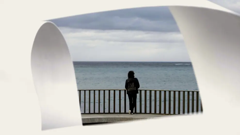 Una persona observa el mar desde el paseo marítimo de La Coruña