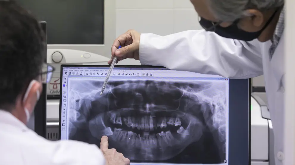 Los doctores Baena y Obón observan la 'foto' de una dentadura tomada con un ortopantomógrafo.