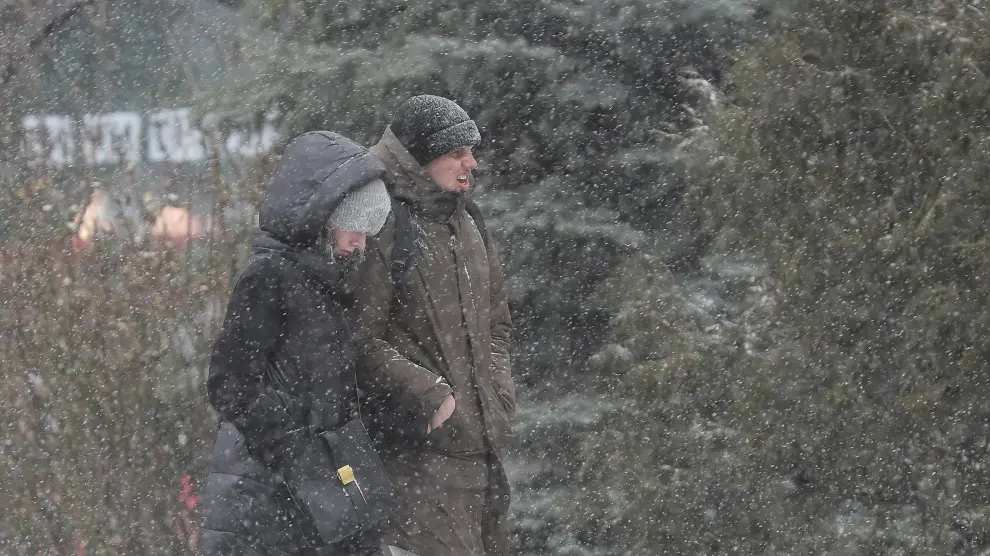 Dos personas caminan bajo la nieve en Kiev, Ucrania, este pasado viernes, 12 de marzo.