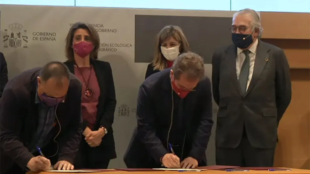 Los representantes sindicales firmando el acuerdo. Detrás, las dos ministras junto a José Bogás.