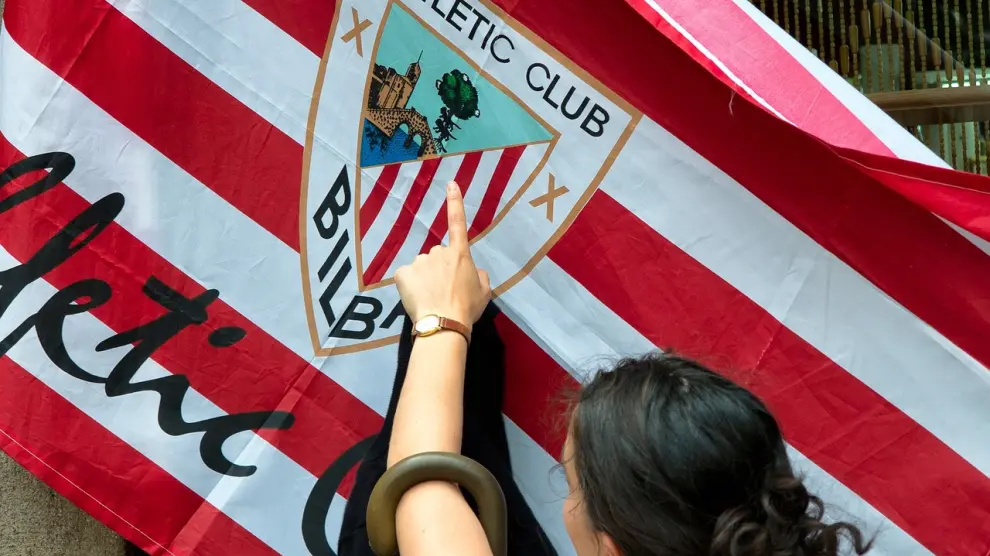 Una mujer señala una bandera del Athletic de Bilbao