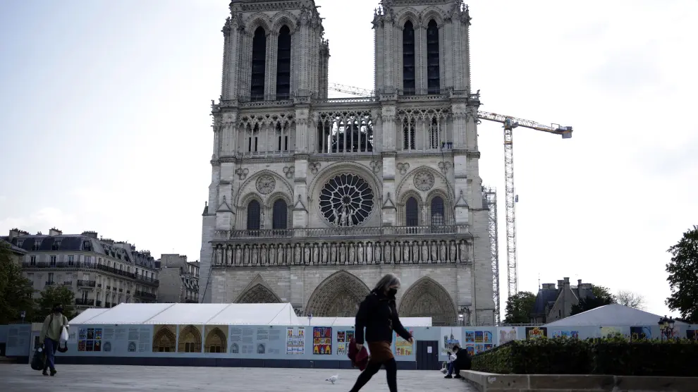 Una mujer pasa por delante de Notre Dame, la víspera de que se cumplan dos años del incendio.