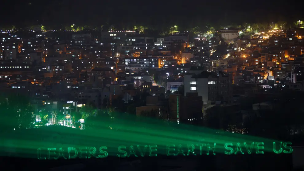 A message that reads "LEADERS SAVE EARTH SAVE US" is projected by Green Peace activists ahead of a climate change summit led by U.S. President Joe Biden, in Seoul