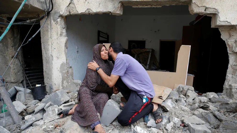 Una madre es besada por su hijo sobre las ruinas de su casa en Gaza.