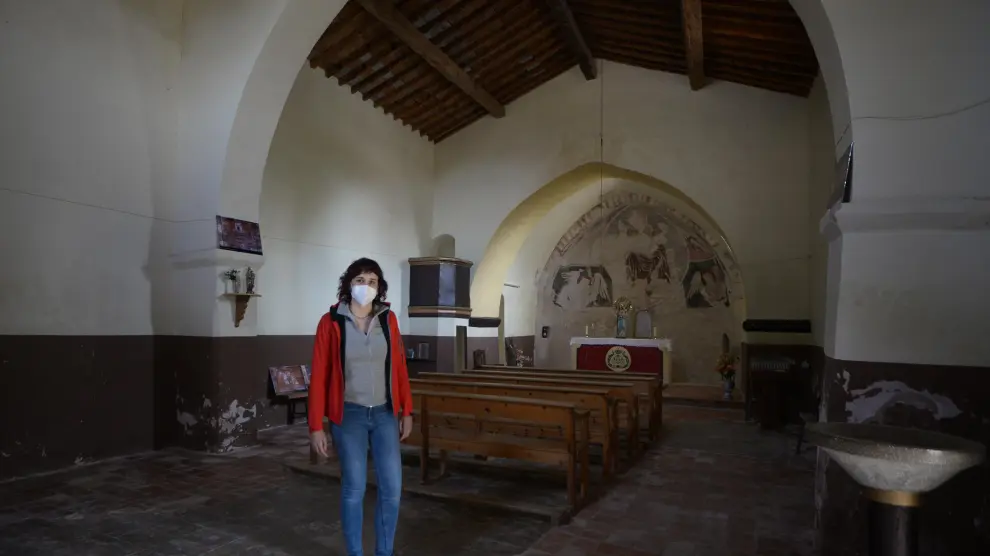 Sara Ros, en el interior de la ermita de Camañas, muestra reproducciones de la decoración de la techumbre.