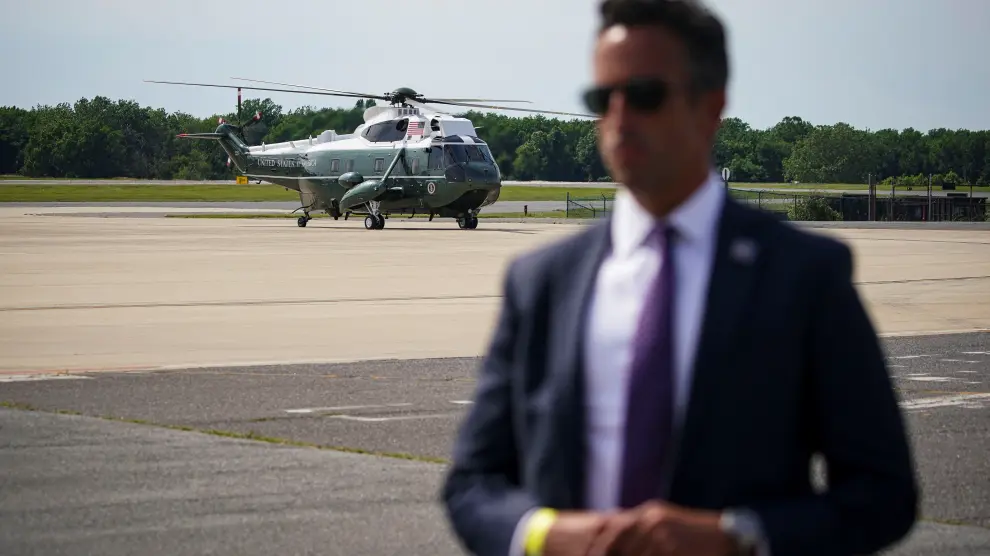 Marine One, carrying U.S. President Joe Biden, arrives past a U.S. Secret Service agent standing guard, as Biden arrives for a weekend trip to his home in Wilmington at Delaware Air National Guard Base