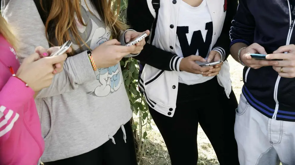 Un grupo de adolescentes reunidos con sus móviles.