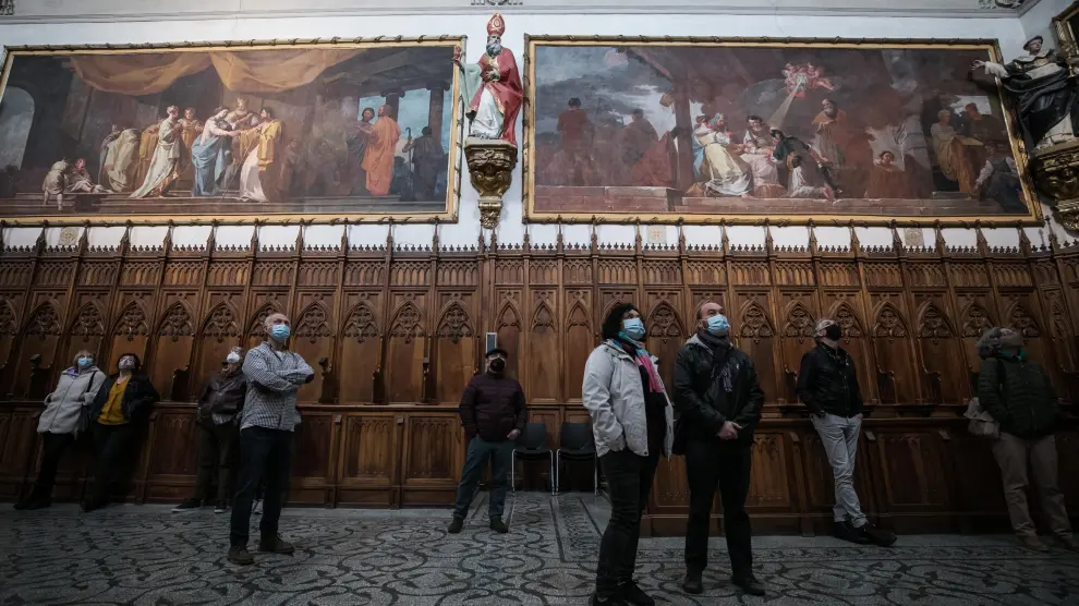 Un grupo de visitantes contempla las pinturas murales de Goya durante una visita guiada a la cartuja de Aula Dei.
