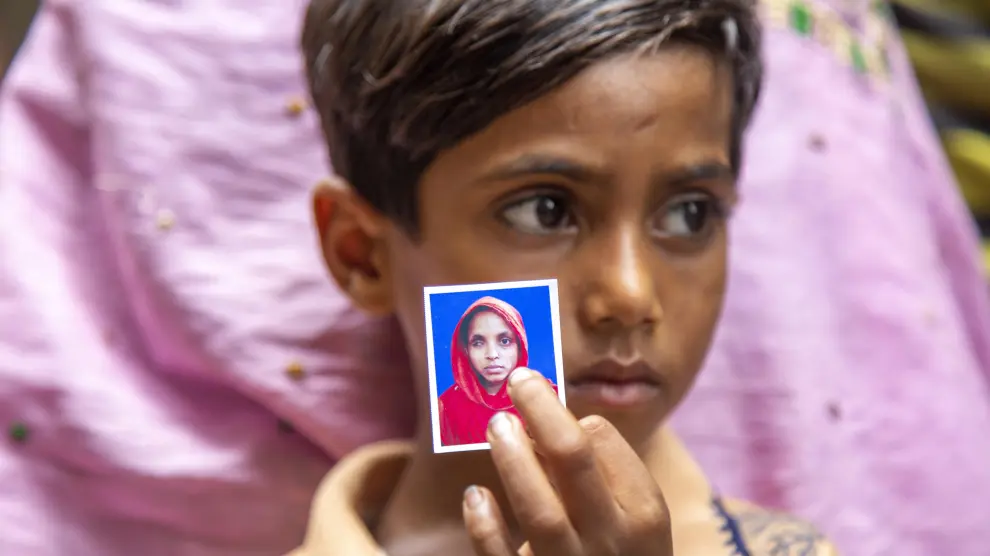 Un niño sostiene la foto de su madre a la entrada de un hospital en Dacca, tras la tragedia en una fábrica de alimentos que ha dejado 54 muertos y decenas de desaparecidos.