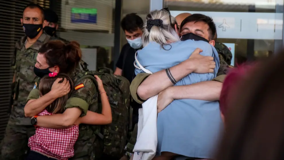 Dos militares de la Brigada Aragón saludan a sus familiares en el aeropuerto de Zaragoza.