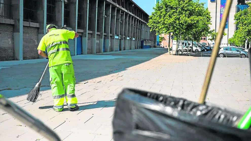Un operario de limpieza barre el suelo junto al estadio de La Romareda, ayer.