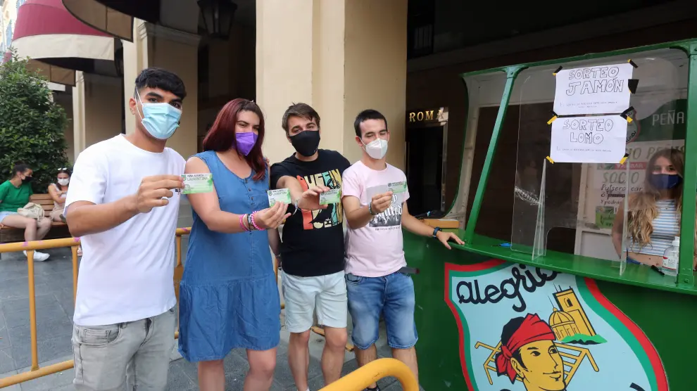 Cuatro jóvenes con su carné recién sacado en el último día de la campaña de socios de las peñas de Huesca.