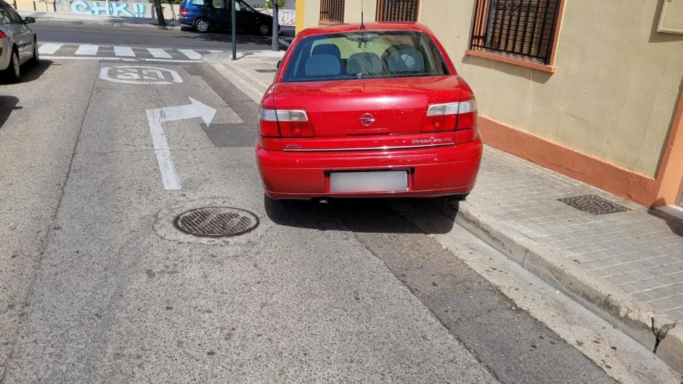 Un coche mal estacionado acaba subido a una acera en el barrio de Torrero-La Paz.