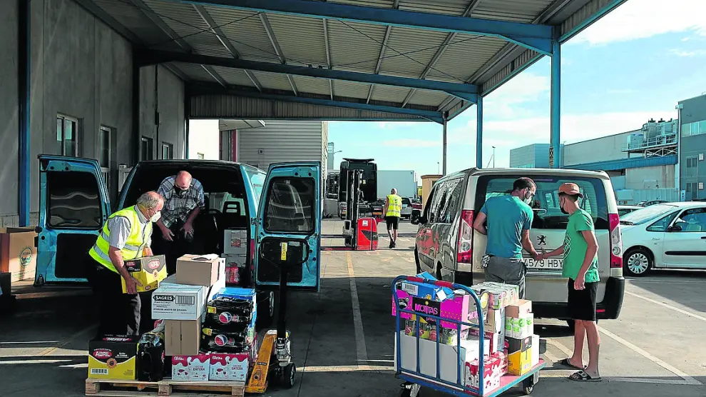 Dos furgonetas cargan alimentos este pasado viernes en el Banco de Alimentos de Zaragoza