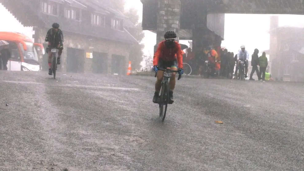 Los primeros ciclistas llegan a la frontera del Somport con la lluvia como protagonista de la jornada.