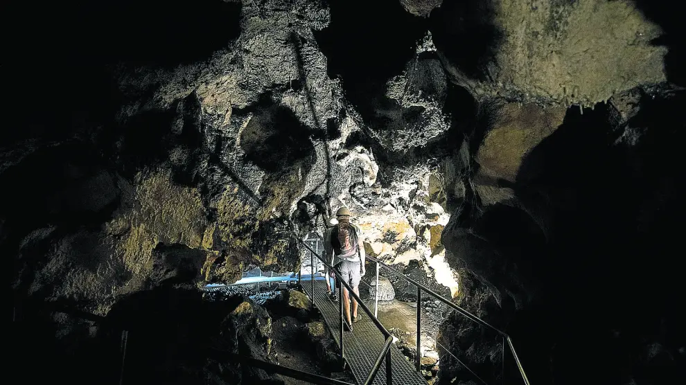 Un grupo de turistas camina por el interior de la misteriosa Cueva del Agua de Fuentespalda.