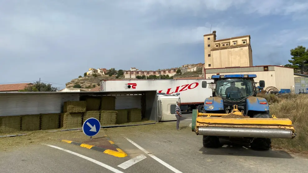 Un camión que transportaba pacas de paja ha volcado esta mañana al tomar la glorieta de acceso a Berbegal
