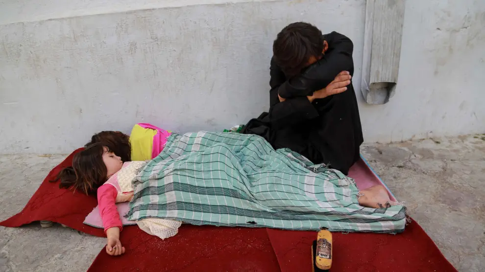 Un hombre junto a sus hijos que duermen en una calle en Kabul, el pasado 28 de septiembre.