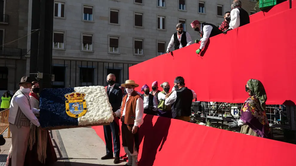 El alcalde de Zaragoza, Jorge Azcón, entrega a la Virgen una bandera de La Palma confeccionada en flores.