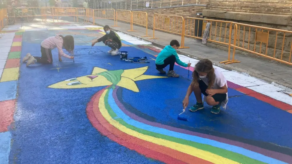Miembros del Consejo de la Ciudad de las Niñas y los Niños de Huesca, pintando una calle peatonal.