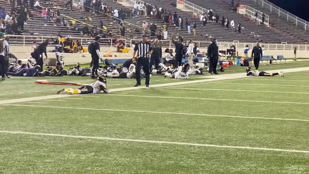 Players lie on the field following gunshots during the Vigor versus Williamson football game at Ladd-Peebles Stadium in Mobile
